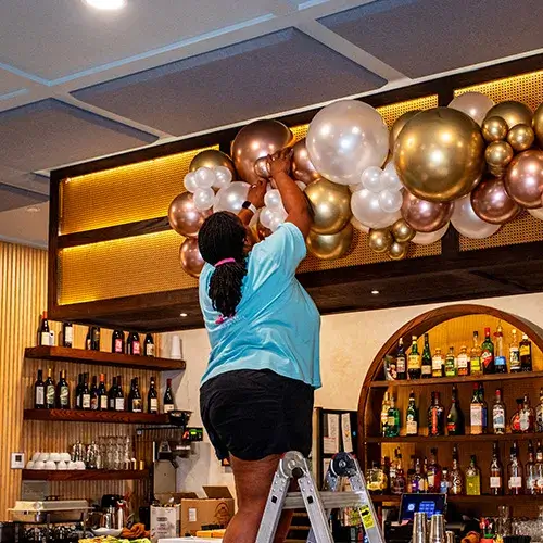 A balloon specialist installing a balloon garland