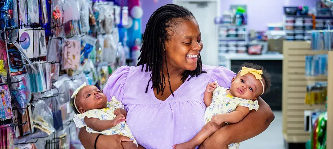 A mom holding her twin babies